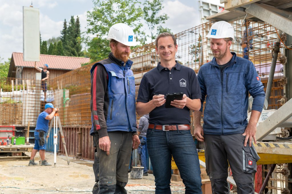 Drei Männer unterhalten sich auf der Baustelle