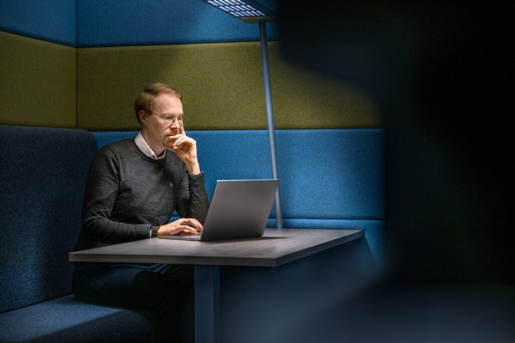 Businessfotografie für Lenkering in Steinfeld: konzentrierte Arbeit am Laptop in der Sitznische