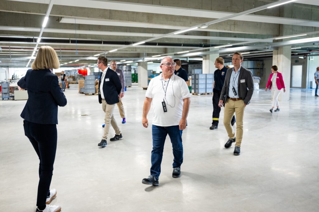 Gäste gehen beim Rundgang durch die neue Halle 43 von Pöppelmann