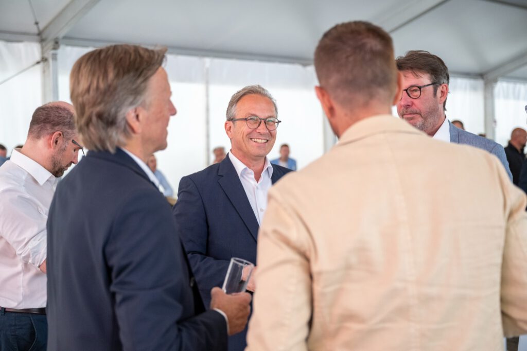 Lachende Gäste im Gespräch im Zelt