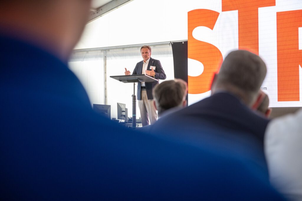 Thomas Nyhsen, Vorstand der STRABAG AG, spricht am Rednerpult im Zelt