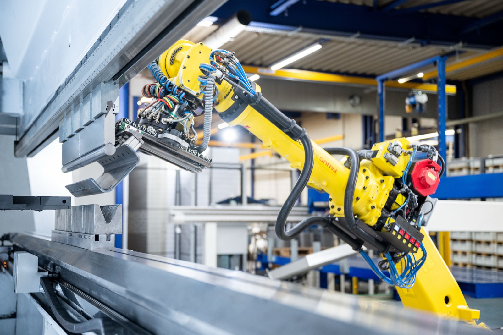 Roboter legt ein Blech in die Abkantpresse bei KUIPERS technologies in Meppen-Hüntel