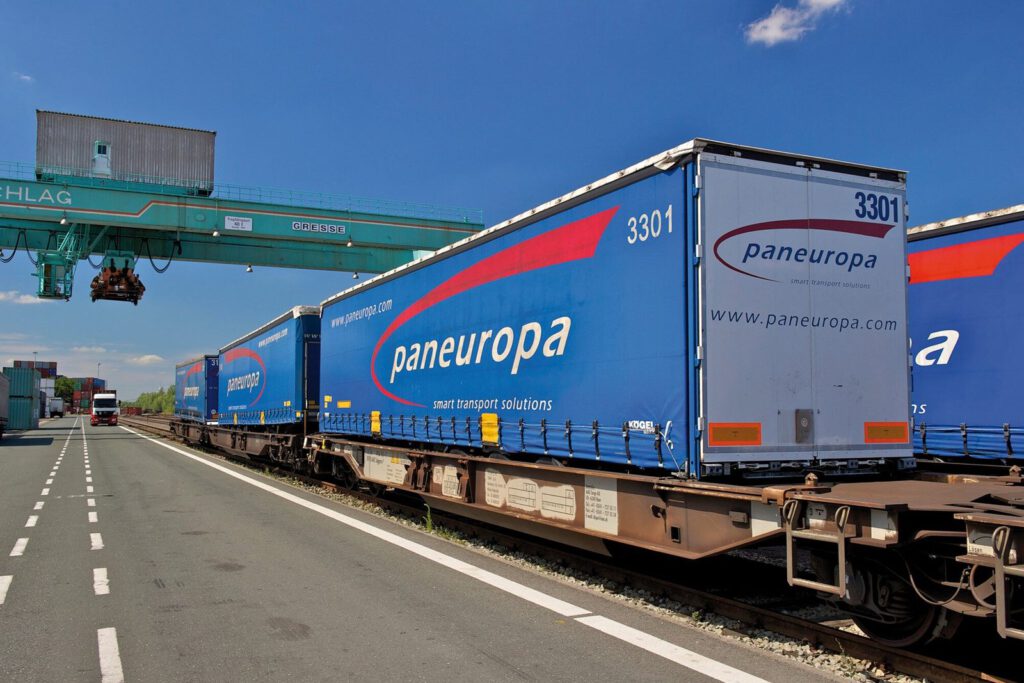 Paneuropa-Auflieger auf einem Güterwagen neben der Fahrspur unter dem Portalkran