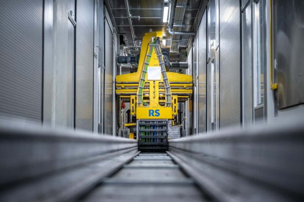 Langer Gang in der Anlage, am Ende gelbe Technik mit RS-Logo