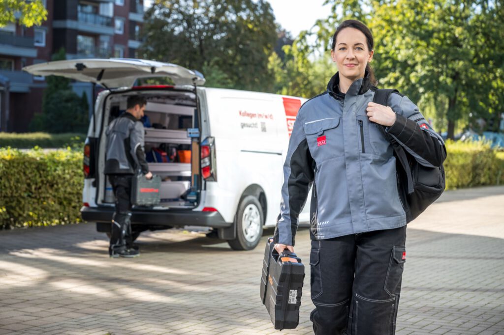 Servicetechnikerin mit Werkzeugkoffer vor einem Servicefahrzeug von STULZ
