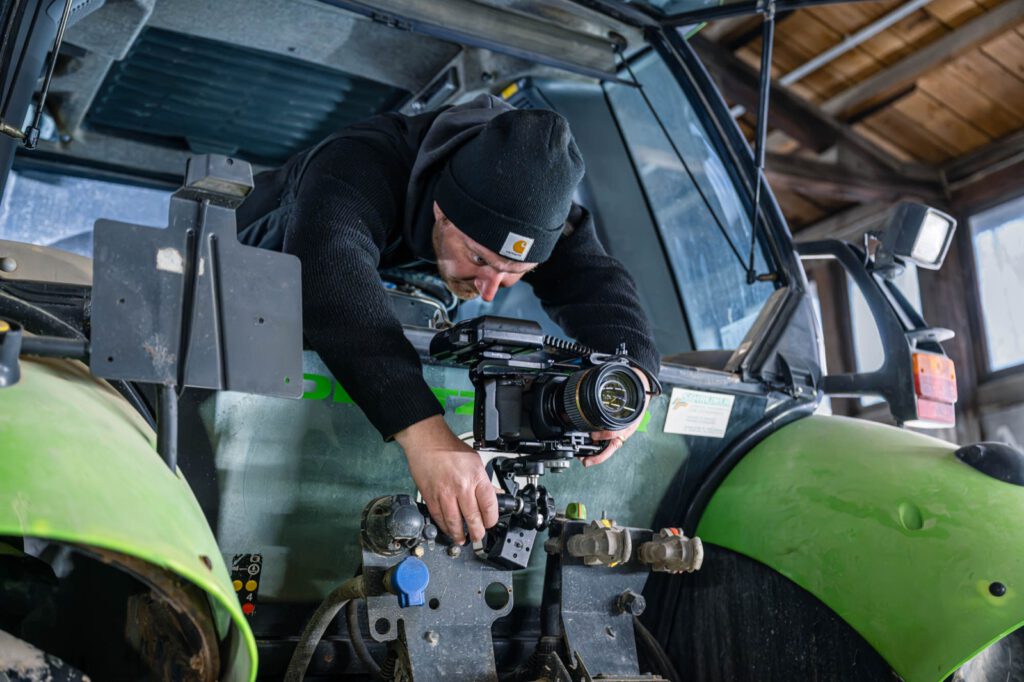 Thomas von Pictoja befestigt eine Filmkamera an einem Traktor