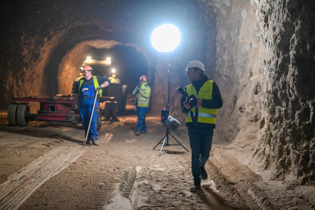 Stollen mit mitgebrachter Leuchte, im Vordergrund ein Fotograf mit Kamera