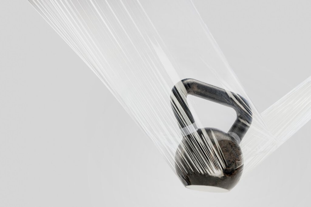 Eine Kettlebell hängt in gedehnter Stretchfolie von DUO PLAST