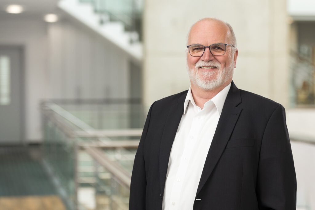 Portrait von Dr. Heiko Greimann, Geschäftsführer von Biochem, vor einem Treppenhaus