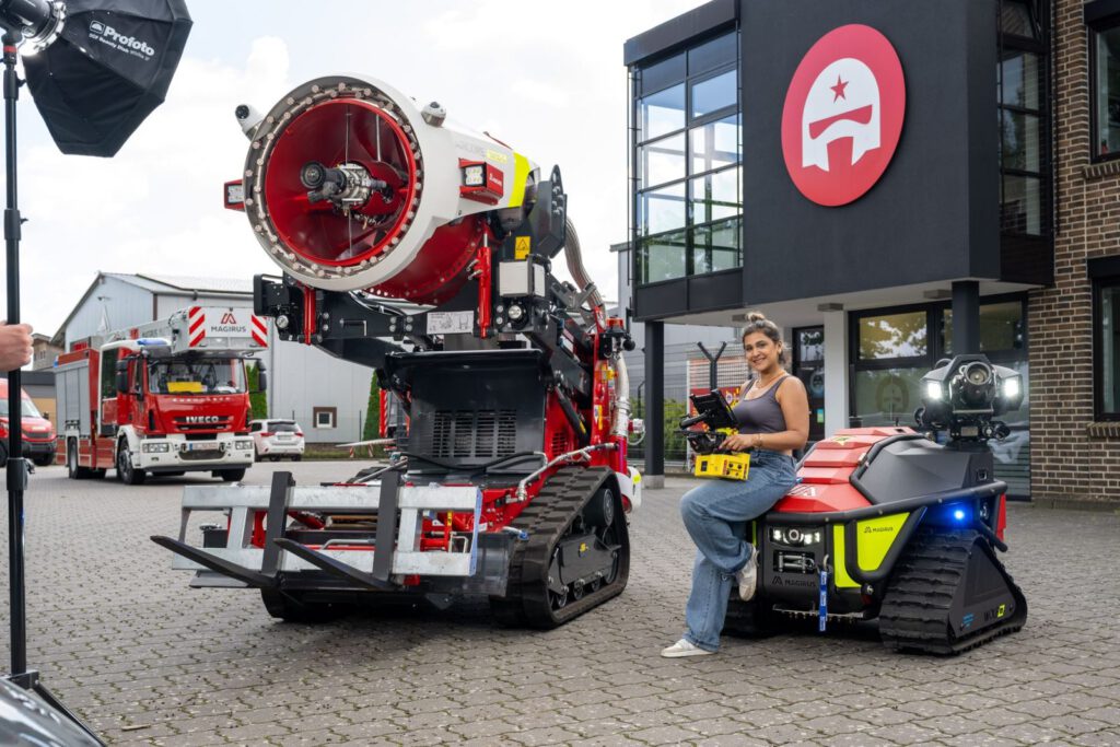 Making-of: Lichttest für die Fotostation vor dem Firmengebäude, Mehregan sitzt mit Fernsteuerung auf einem Roboter, links eine Softbox