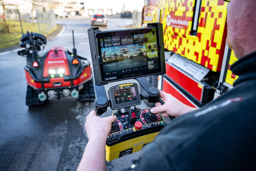 Fernbedienung mit Tablet, im Hintergrund der Wolf R1