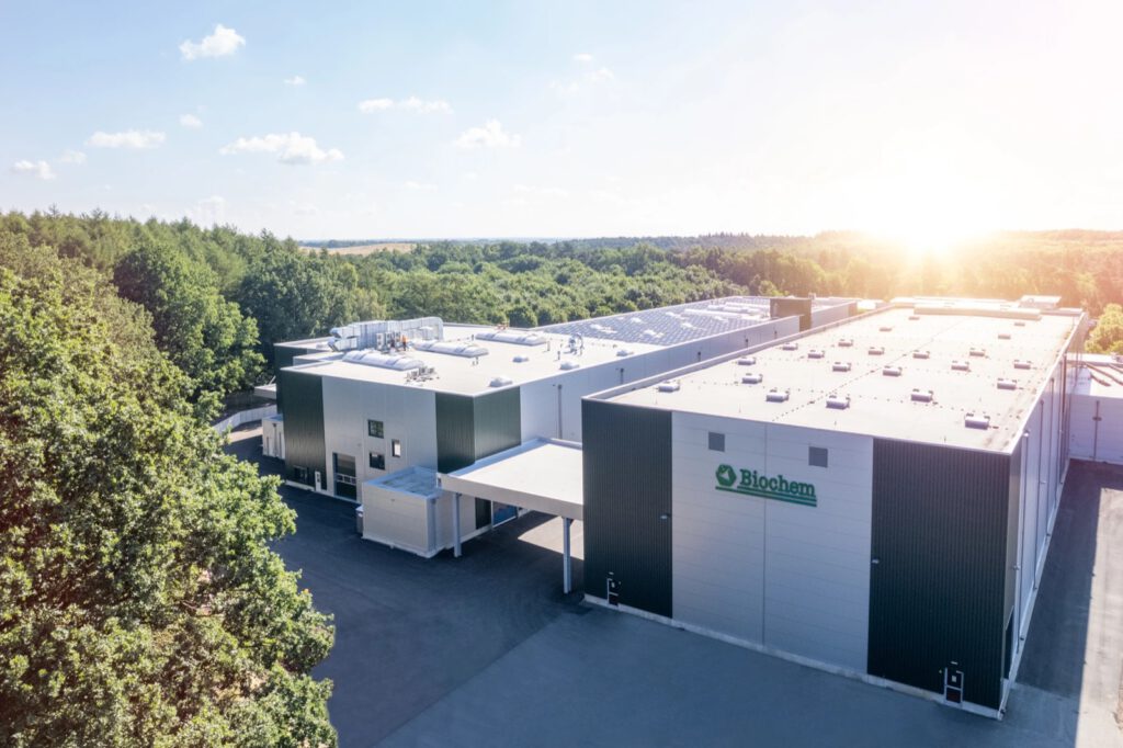 Luftaufnahme des Biochem-Werks am Brägeler Forst in Lohne im Morgenlicht, umgeben von Wald