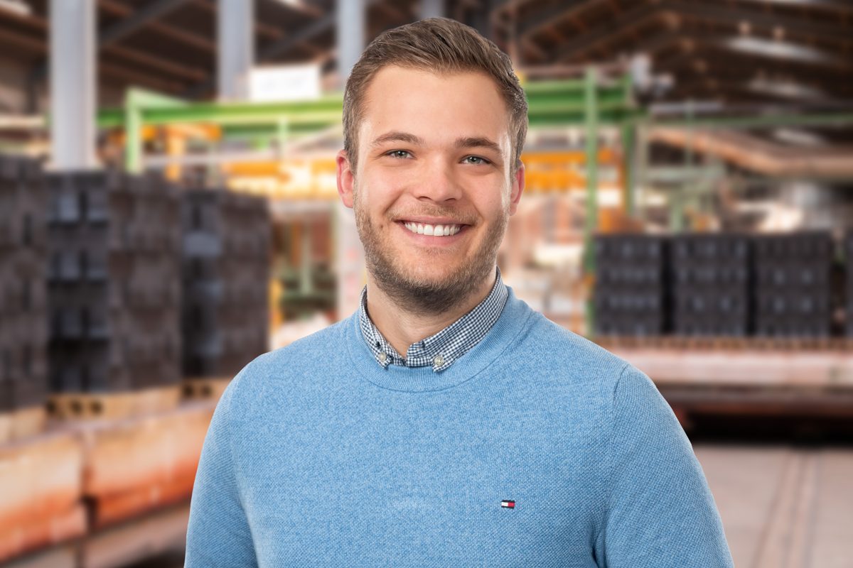 Junger Mann im hellblauen Pullover in der Produktion